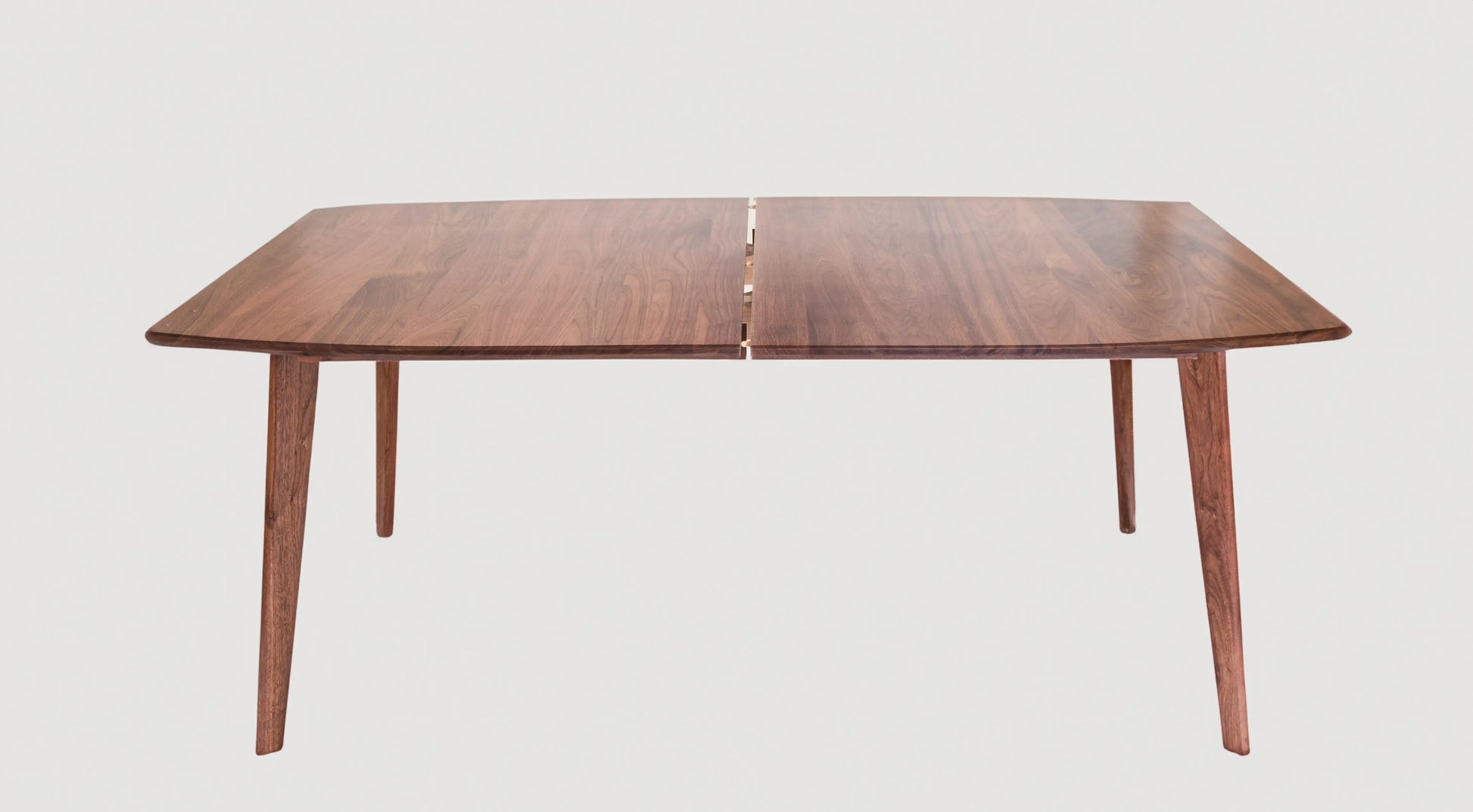 The Santa Monica Extension Table: Mid Century Modern extendable dining table with angled wooden legs and semi-elliptical shape, showcasing classic and modern design.