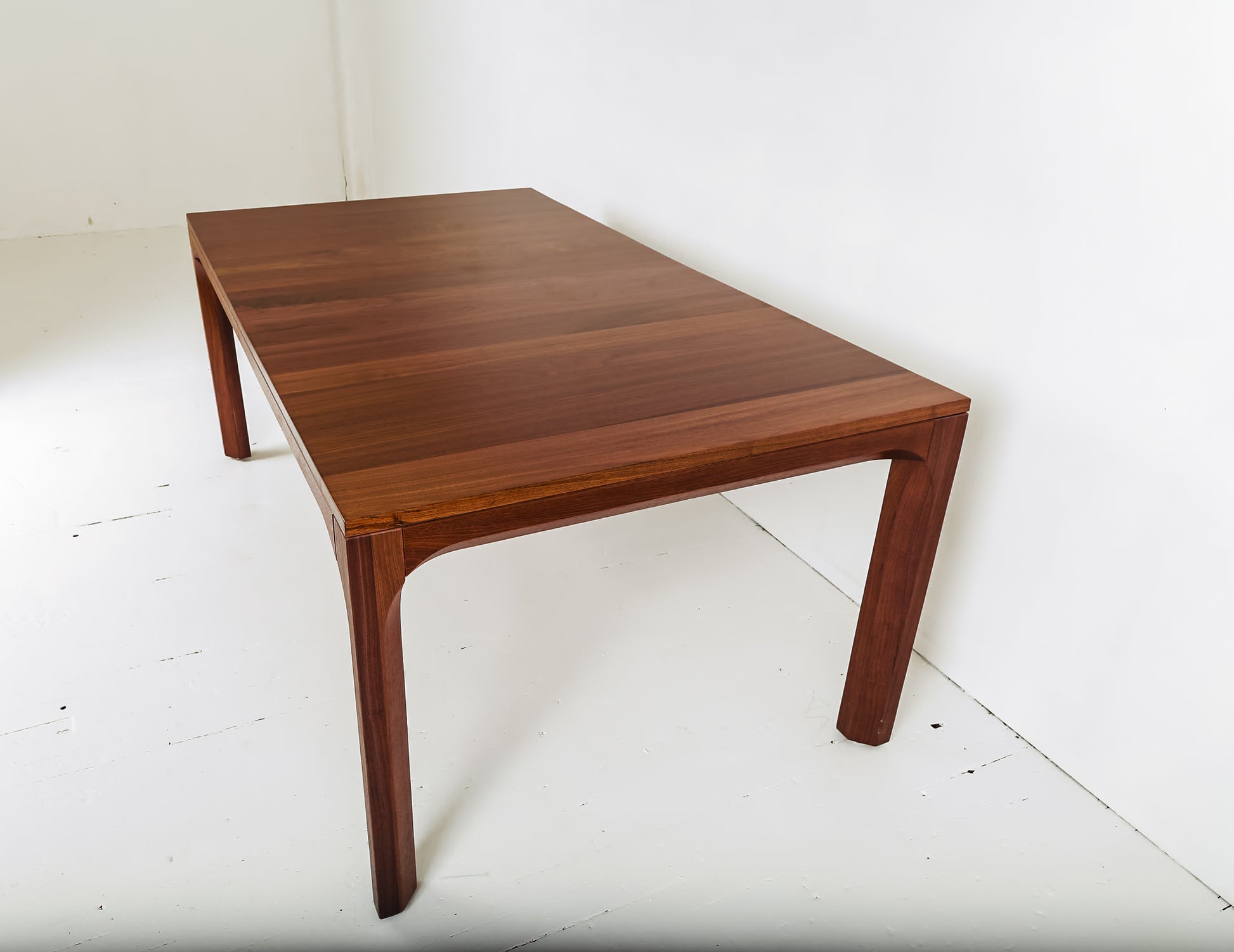 Minimalist dining setup with walnut dining table and bold orange chairs
