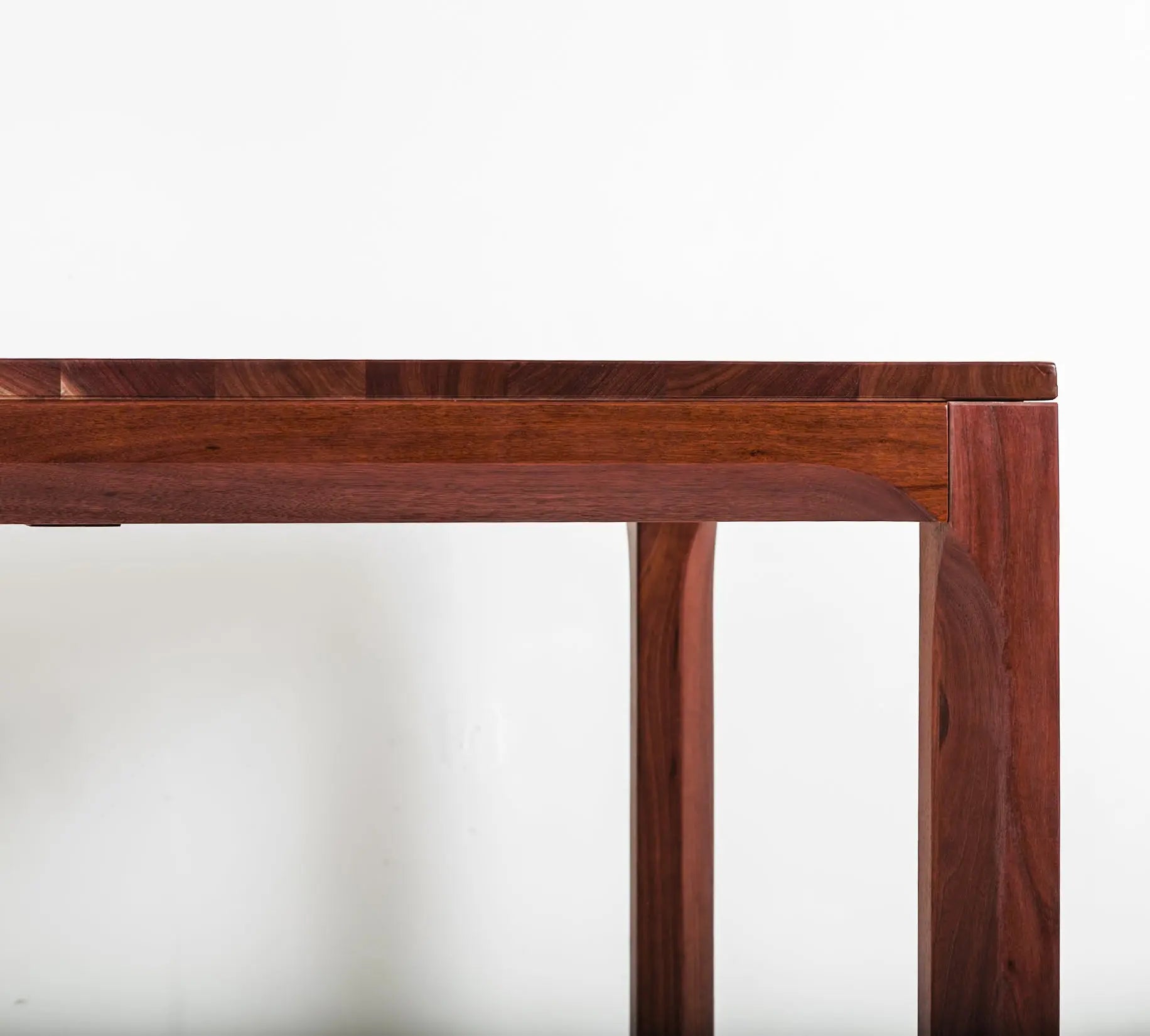 Walnut wood dining table in a bright, minimalist dining room
