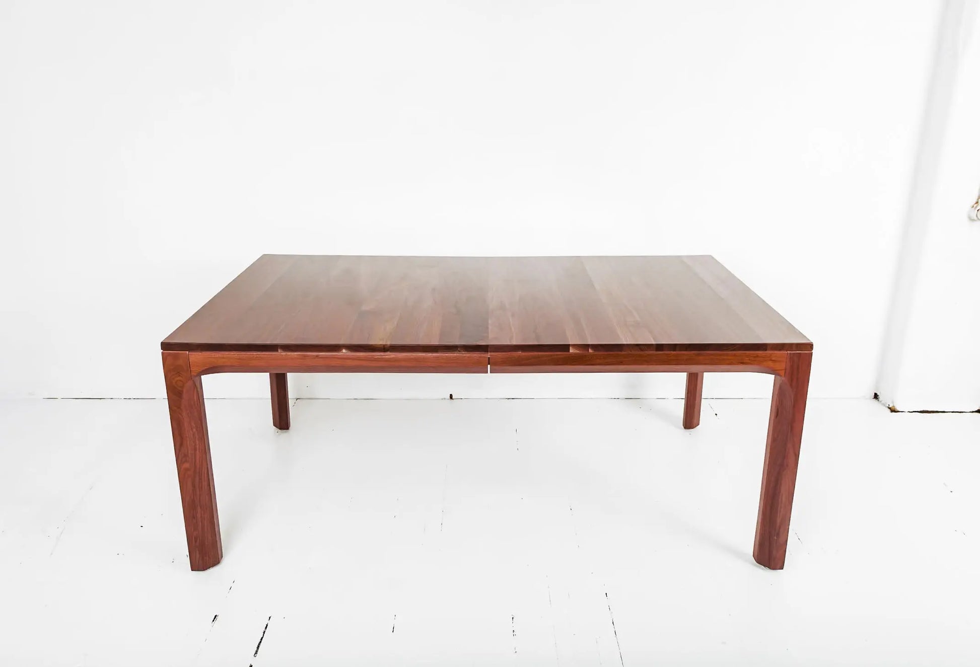 FSC-certified walnut dining table with customizable leaf extensions
