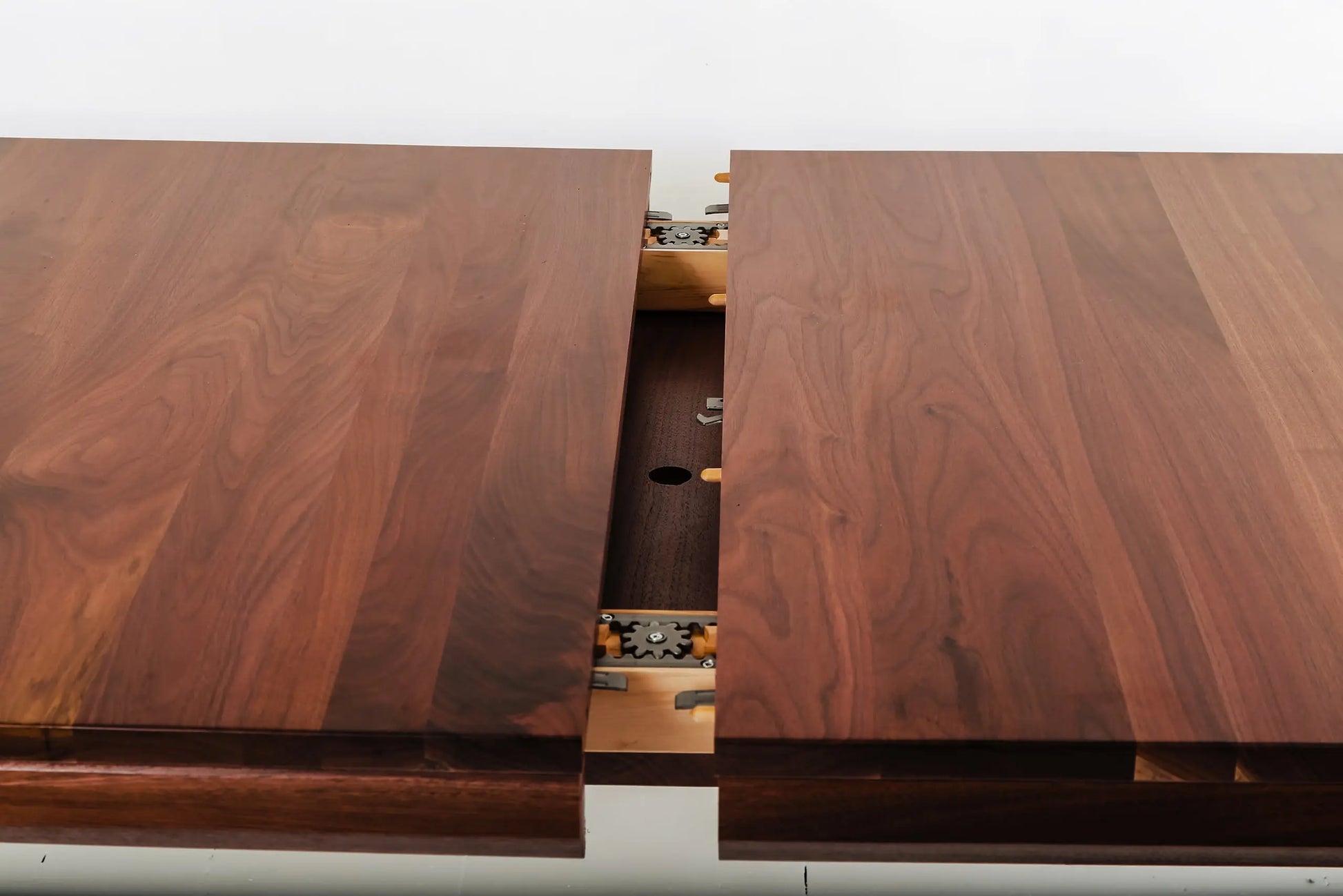 Contemporary walnut dining table with orange chairs and minimalist decor
