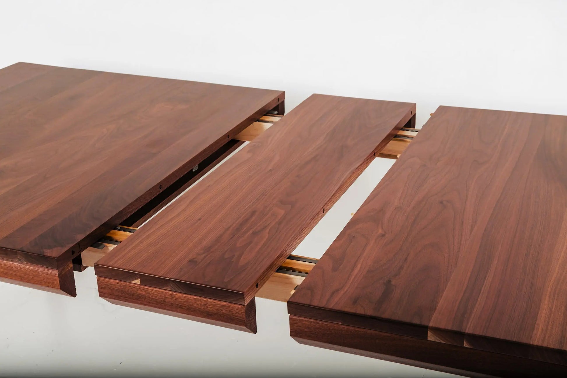 Walnut wood dining table with a bench and minimalist orange chairs
