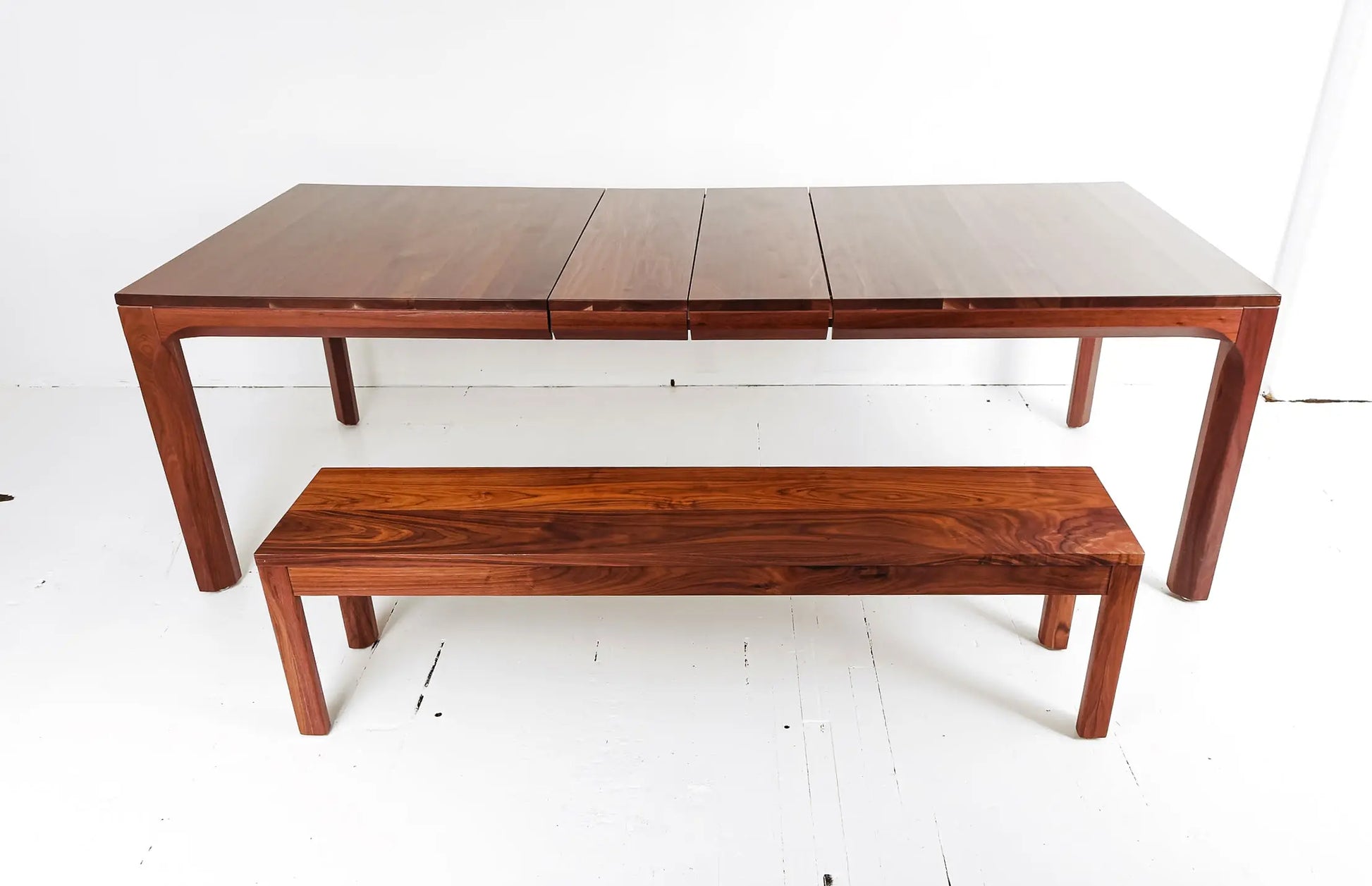 Handcrafted walnut dining table with mid-century design and vibrant seating
