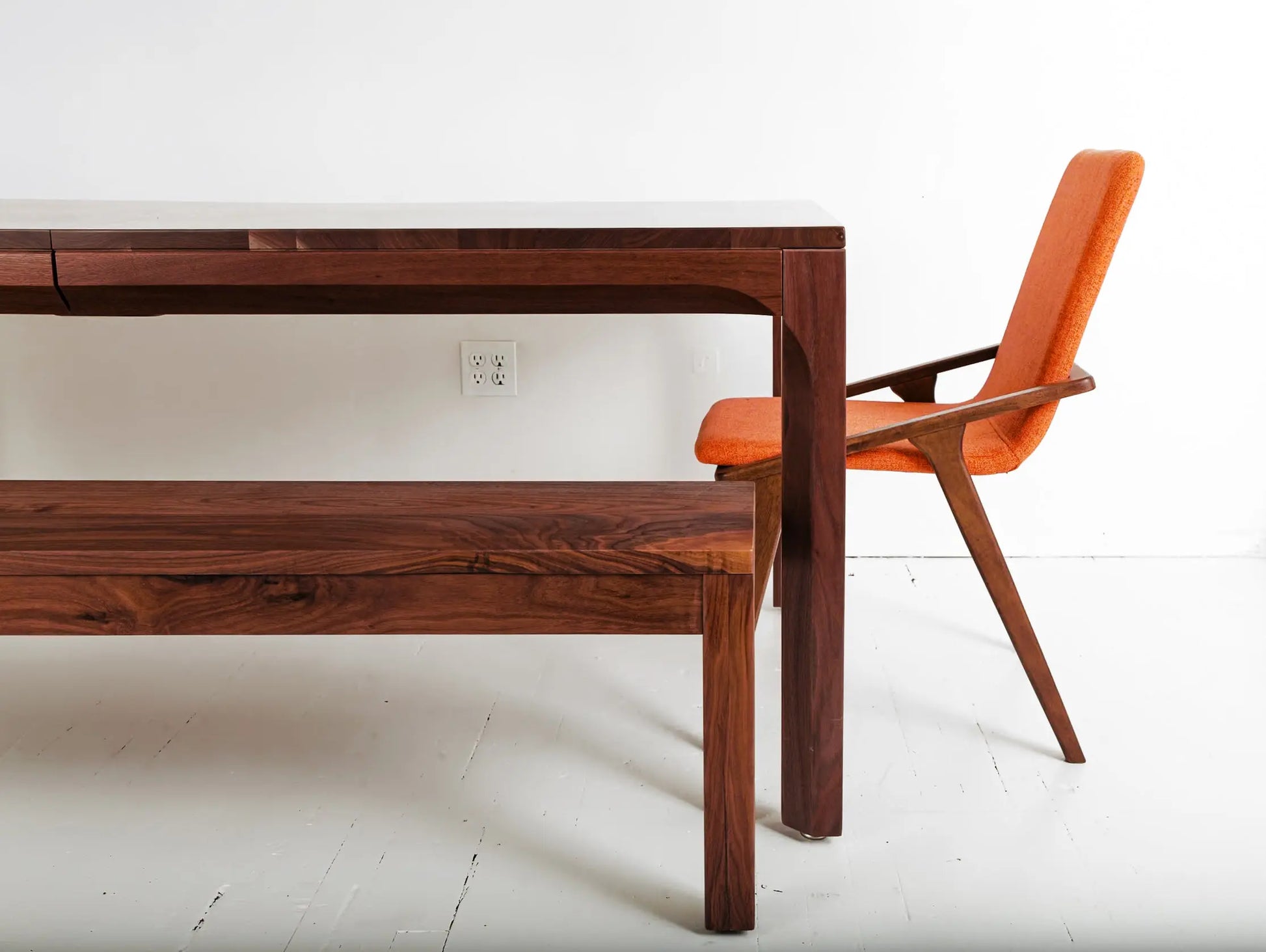 Walnut dining table with bench for modern, minimalist dining room setup
