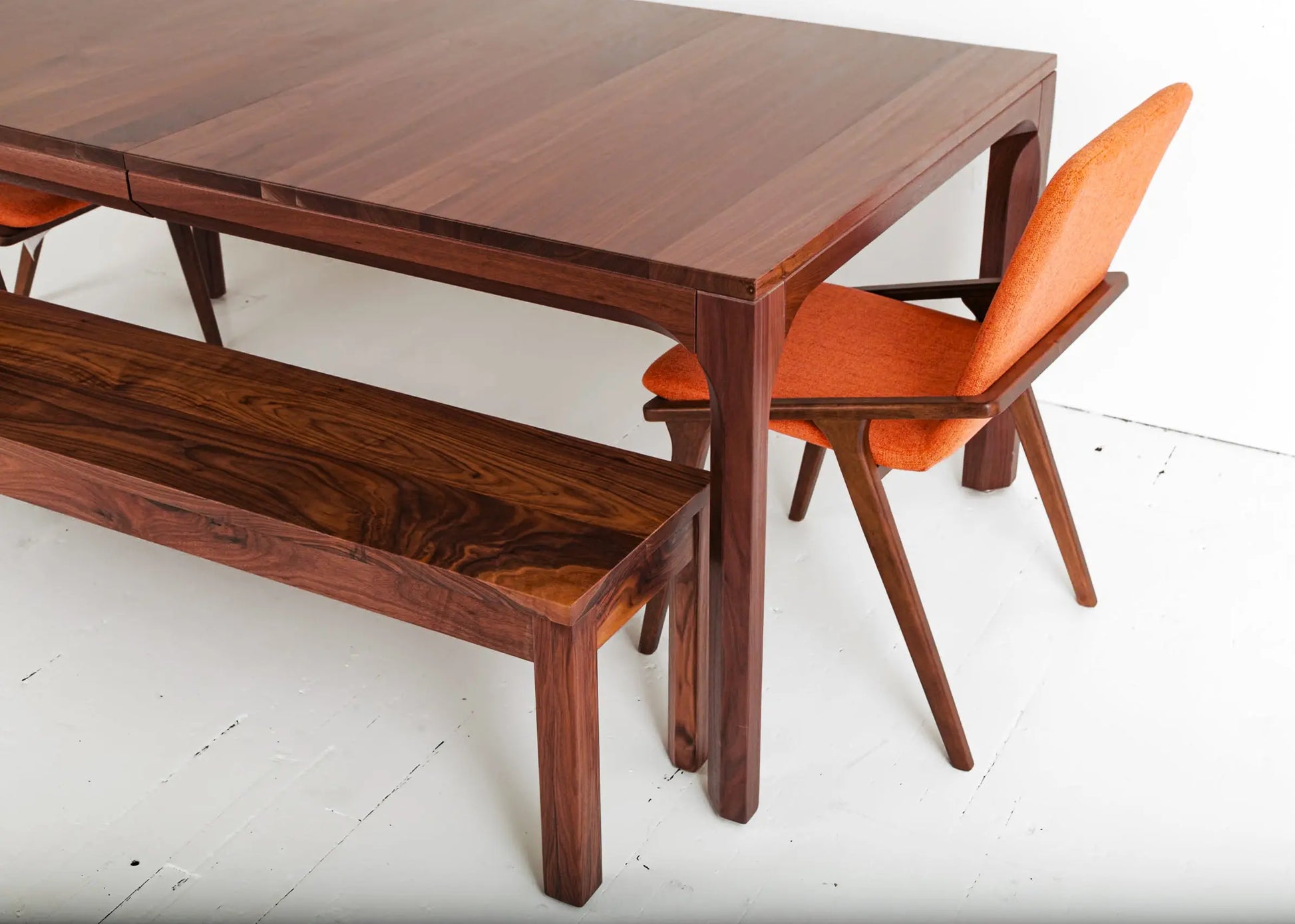 Walnut dining table in a minimalist interior with bright accent furniture
