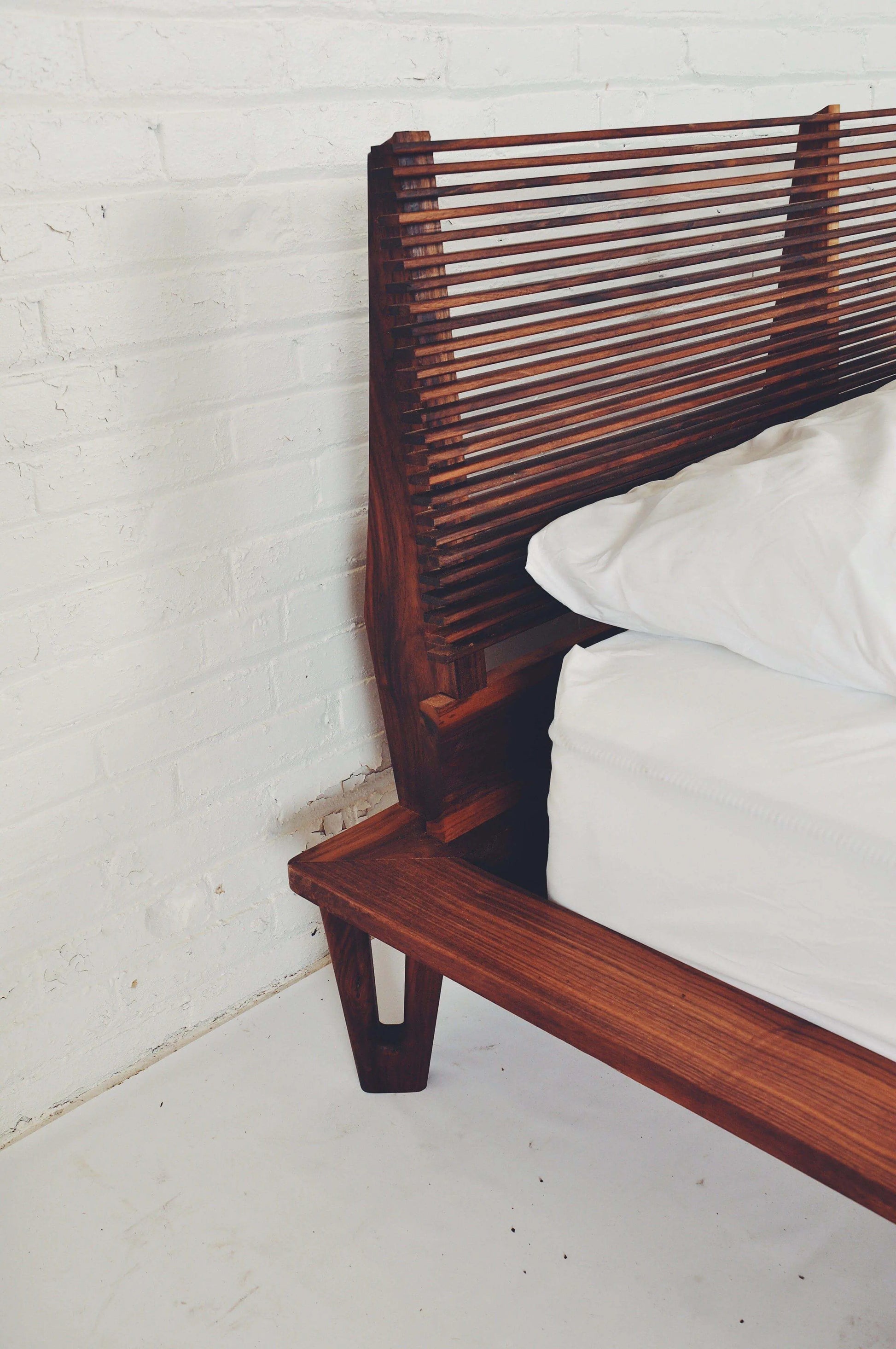 Detailed view of The Baxter's custom split leg design in solid Walnut