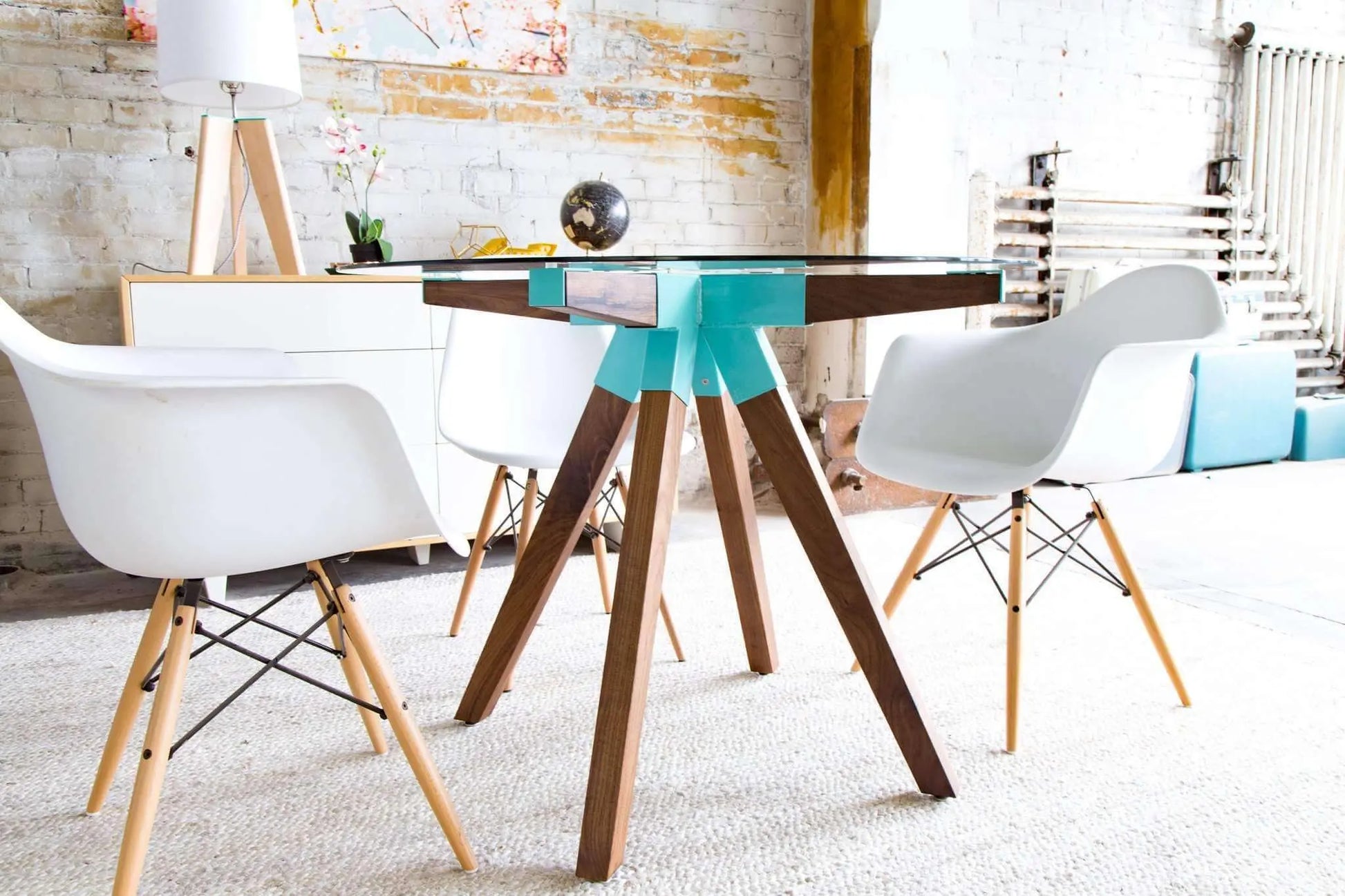 Sleek mid-century glass dining table with tapered wooden legs