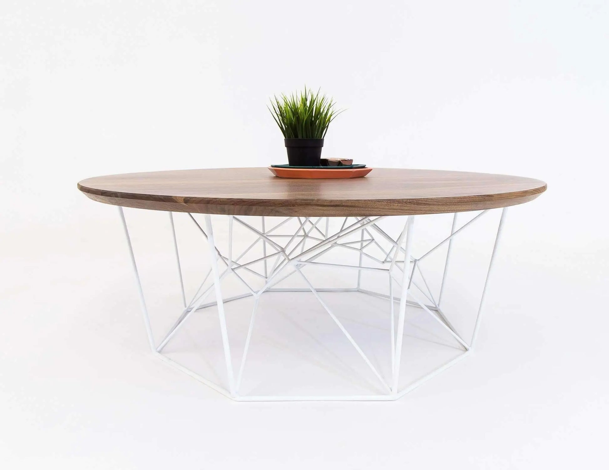 The Mila round coffee table with smooth walnut finish and tapered legs