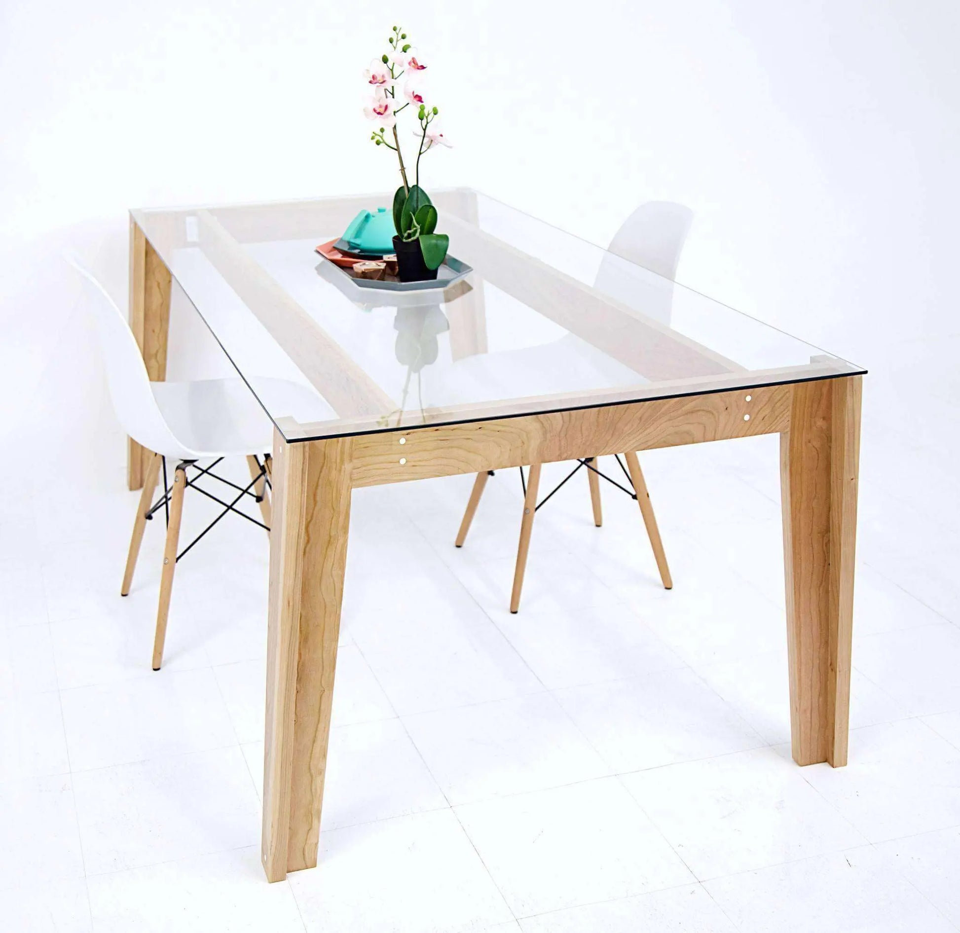 Minimalist mid-century dining table with transparent glass surface