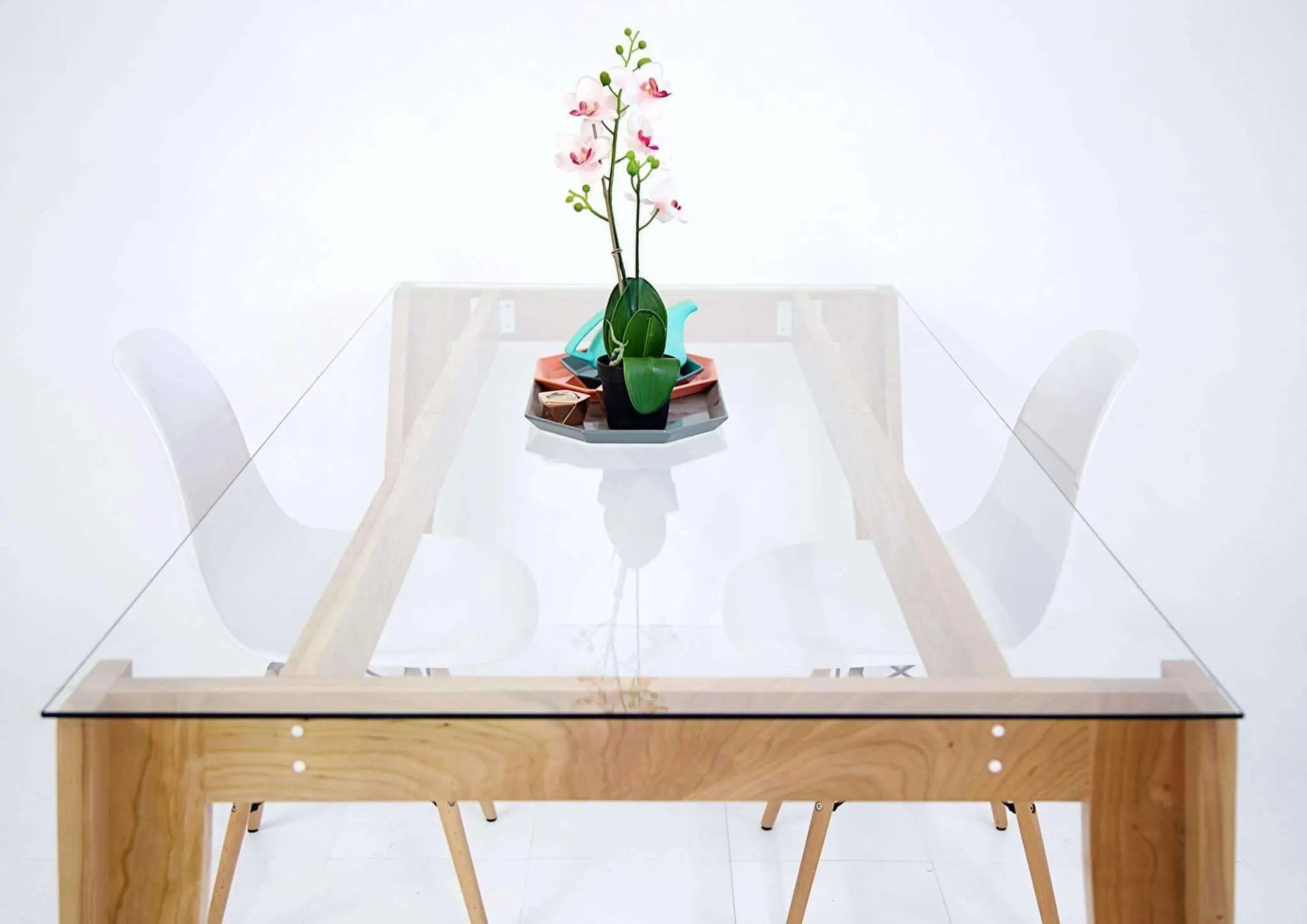 Solid wood dining table with a transparent glass top and clean lines