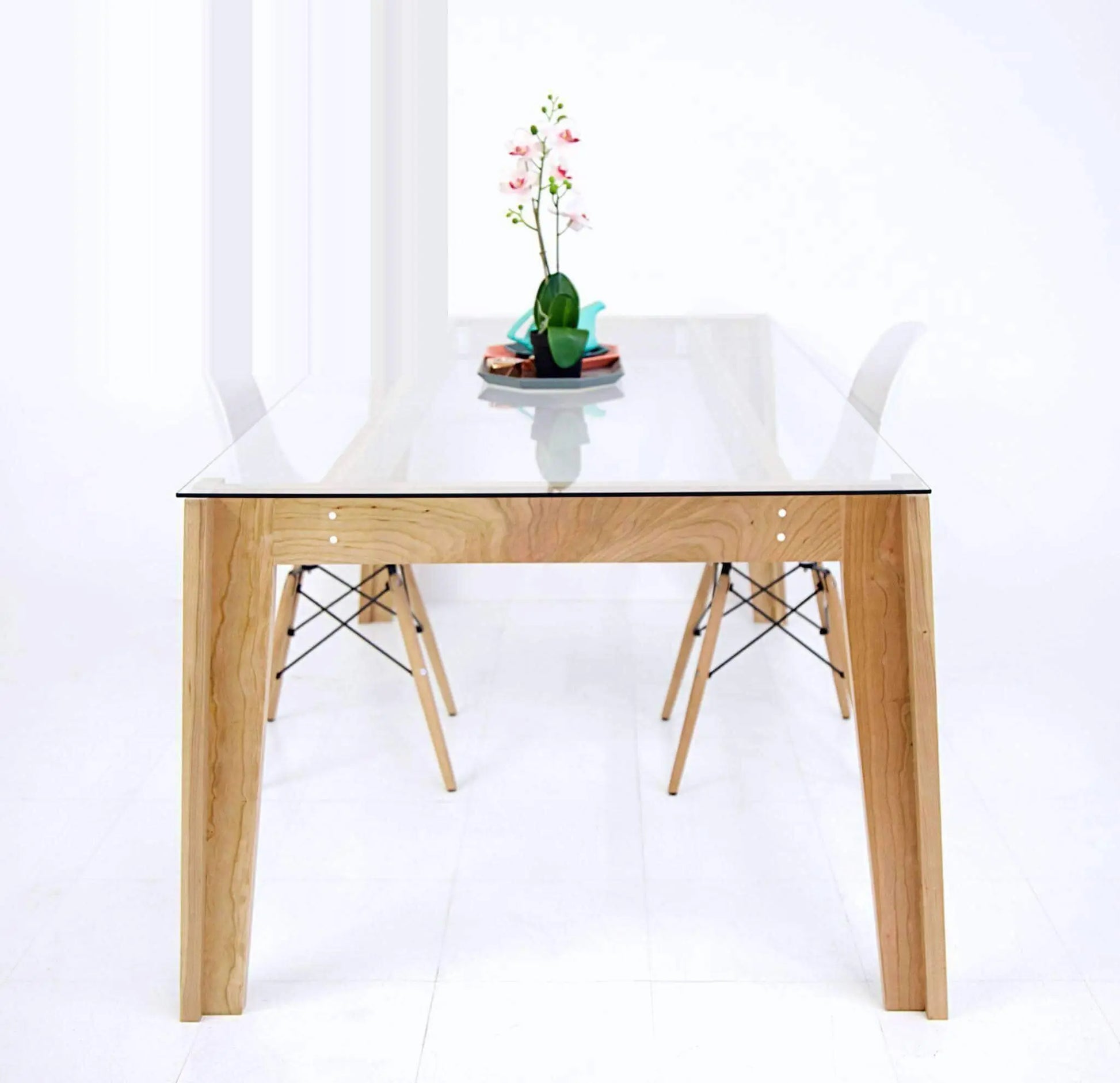 Modern glass-top dining table with angular wooden base