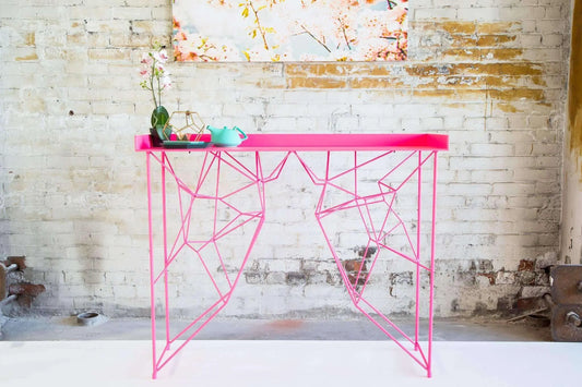 Minimalist pink console table with tapered legs and vintage charm